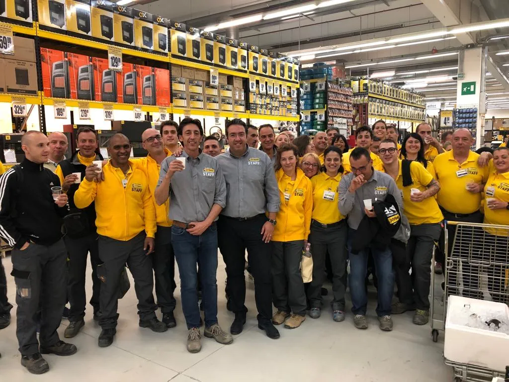 Gruppo di collaboratori riuniti nel punto vendita durante un momento celebrativo